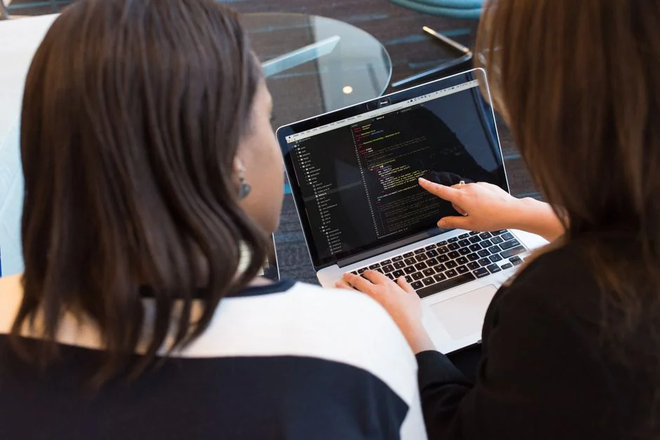 Un espace de travail moderne avec deux écrans d’ordinateur affichant des projets de conception web, mettant en avant la technologie et la productivité.