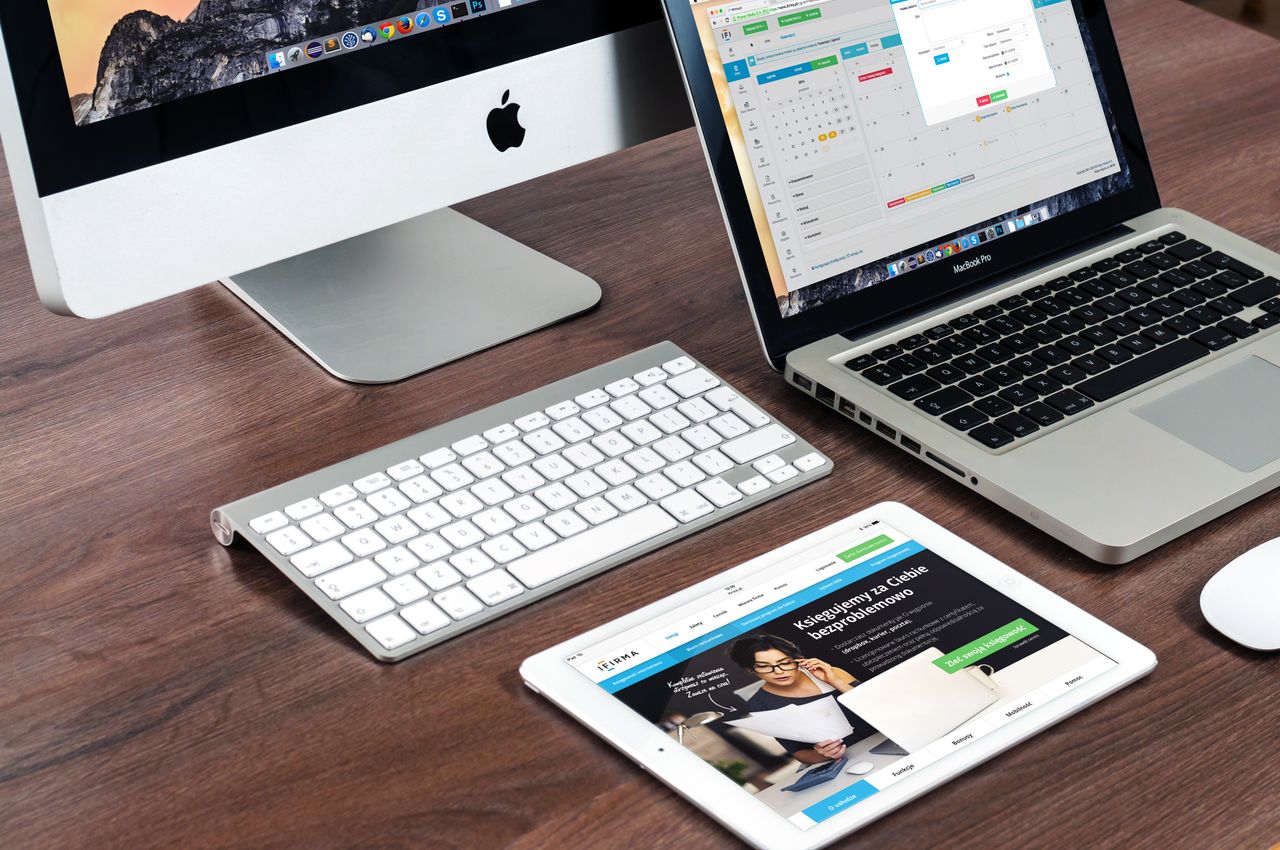 A refined office desk arrangement with Apple devices: iMac, MacBook, and iPad.
